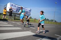 U.S Air Force Maj. Derek Huber, center, 352nd Special Operation Support Squadron flight commander, and youth duathlon participants cross the finish line during the RAF Mildenhall Fitness Center 3rd Annual Duathlon July 23, 2016, on RAF Mildenhall, England. The duathlon is one of several events the fitness center hosts as a way to promote fitness and boost base-wide camaraderie. (U.S. Air Force photo by Senior Airman Christine Halan) 
