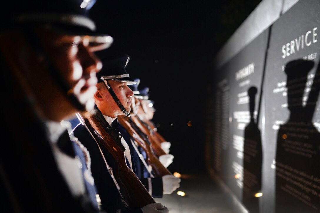 Airmen read inscriptions on the face of the Air Force Memorial before participating in ceremonial drill training in Arlington, Va., July 26, 2016. The airmen are assigned to the Air Force Honor Guard. Air National Guard photo by Staff Sergeant Christopher S. Muncy