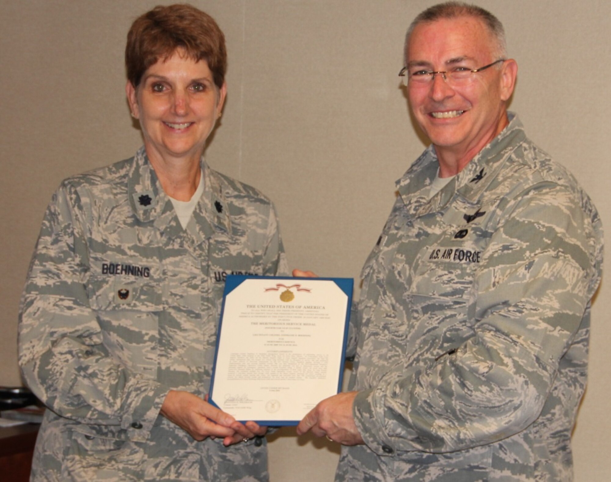 Lt. Col. Stephanie Boehning, process improvement manager at the 932nd Airlift Wing, is presented the Meritorious Service Medal by the commander of the wing, Col. Jonathan Philebaum.  Boehning distinguished herself in the performance of outstanding duty while assigned to the unit in Illinois from 15 June 2009 to 14 June 2014.  She led the Mission Support Flight conversion to Force Support Squadron and merged two critical wing functions with no disruption to service.   She was handpicked as the 2010 Inspection Emergency Operations Center Deputy Director and conducted multiple key Air Force Smart Operations events.  Her efforts boosted morale and productivity for more than six hundred airmen. (U.S. Air Force photo by Maj. Stan Paregien)