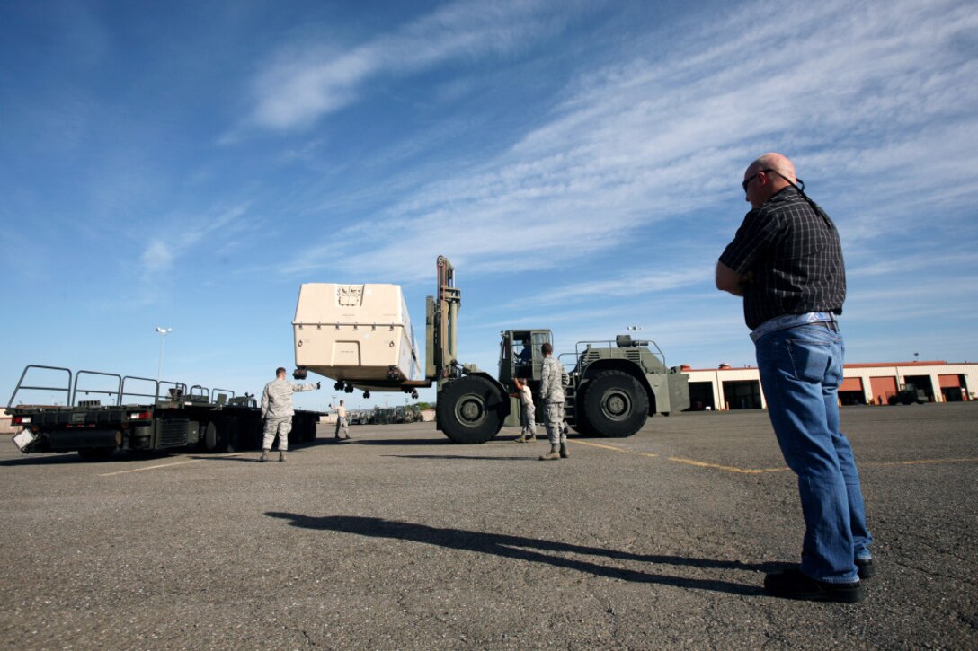 John "Buck" Buchanan, front right, watches as members of the 60th Aerial Port Squadron use a forklift to load a piece of cargo at Travis Air Force Base. DLA’s Warfighter Support Representatives visited Buchanan and the 60th APS as part of WSR training at DLA Distribution San Joaquin, Calif. 