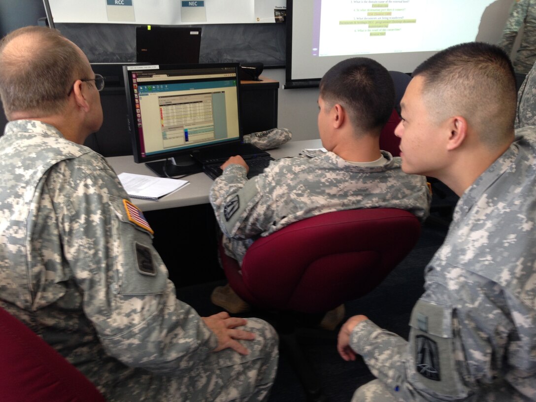 Chief Warrant Officer 2 Hermes Yen (right), Western Cyber Protection Center, looks at the network with his teammates as they try and maneuver around digital obstacles set up during the Cyber X-Games training exercise in Monterey, Calif.