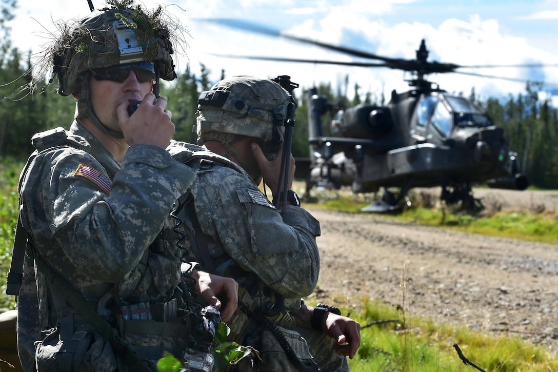 An AH-64 Apache attack helicopter lands on a road as soldiers radio reports during an opposing forces attack, July 25, 2016, as part of Arctic Anvil 2016, an exercise in Donnelly Training Area near Fort Greely, Alaska. The soldiers are assigned to the 25th Infantry Division’s Company A, 1st Battalion, 24th Infantry Regiment, 1st Stryker Brigade Combat Team, Alaska. The multinational exercise includes active duty soldiers, the Iowa National Guard’s 133rd Infantry Regiment and a Canadian unit. Air Force photo by Justin Connaher