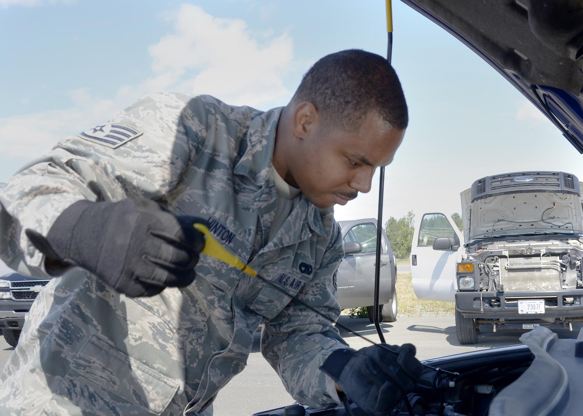 Staff Sgt. Mario D. Hinton, a vehicle operator for the 445th Logistics Readiness Squadron, Wright-Patterson Air Force Base, Ohio,  checks the oil in a vehicle July 19, 2016 at Joint Base Elmendorf Richardson, Alaska. Hinton and his fellow reservists are helping the 673rdrd LRS ensure vehicles are prepared for their upcoming air show taking place July 30-31, 2016. (U.S. Air Force photo/Senior Airman Joel McCullough)
