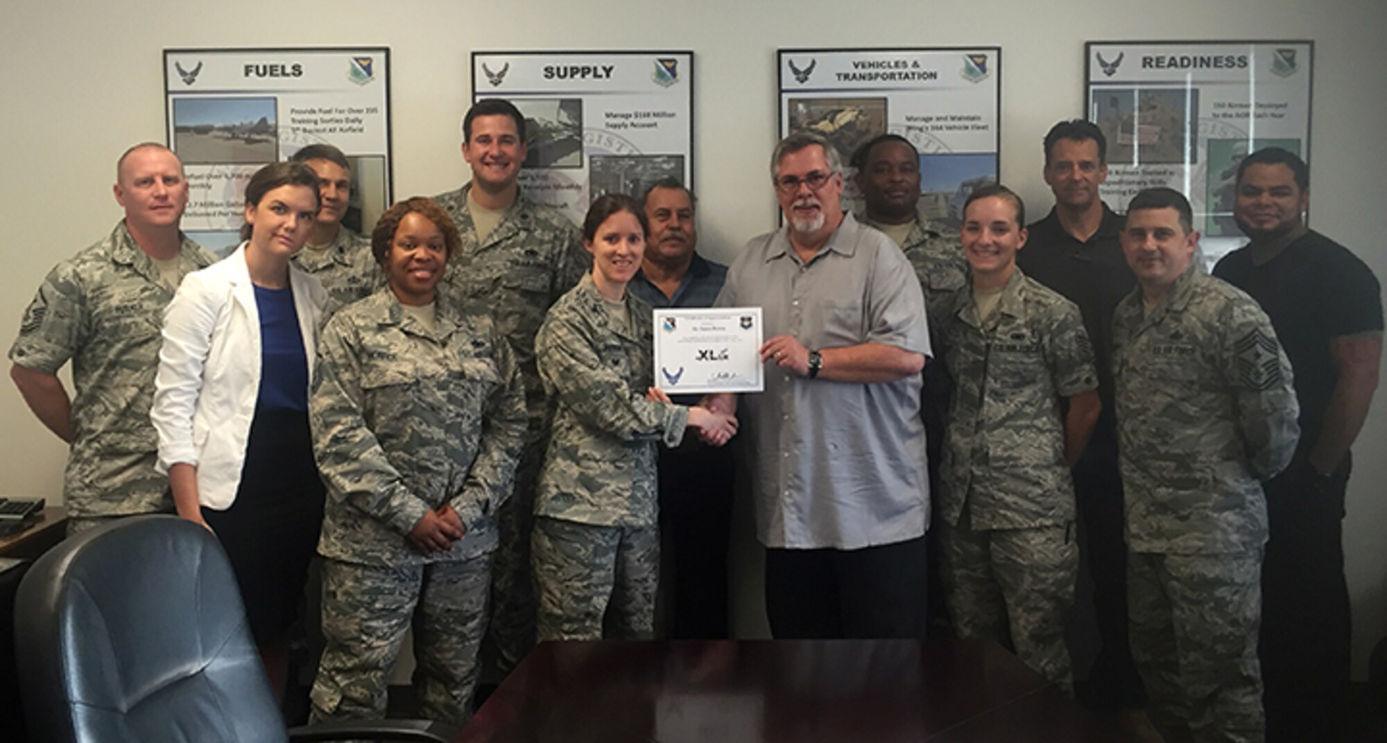 James Brown, front right, 47th Flying Training installation deployment officer, accepts the “XLer of the Week” award from Col. Michelle Pryor, front left, 47th Flying Training Wing commander, here, July 20, 2016. The XLer is a weekly award chosen by wing leadership and is presented to those who consistently make outstanding contributions to their unit and Laughlin. (Courtesy photo)