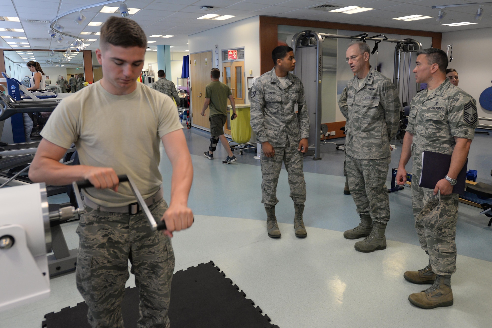 U.S. Air Force Senior Airman Daniel Dawson (left), 48th Medical Operations Squadron physical therapy assistant, demonstrates the use of a BTE machine as Staff Sgt. Macros Davis, 48th MDOS physical therapy assistant, briefs Lt. Gen. Mark A. Edigar, Surgeon General of the Air Force, and Chief Master Sgt. Jason E. Pace, Chief, Medical Enlisted Force, on the types of equipment in the 48th Medical Group’s Physical and Occupational Therapy Clinic at Royal Air Force Lakenheath, England, July 25. Ediger and Pace visited many of the 48th MDG’s facilities during their tour to engage with the Airmen and see first-hand the capabilities of the MDG. (U.S. Air Force photo/Airman Eli Chevalier)