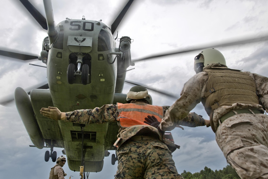 A Marine uses hand and arm signals to direct a CH-53E Super Stallion during a support team exercise at Camp Lejeune, N.C., July 19, 2016. Students attended the exercise as part of their required entry-level training. Marine Corps photo by Lance Cpl. Manuel A. Serrano