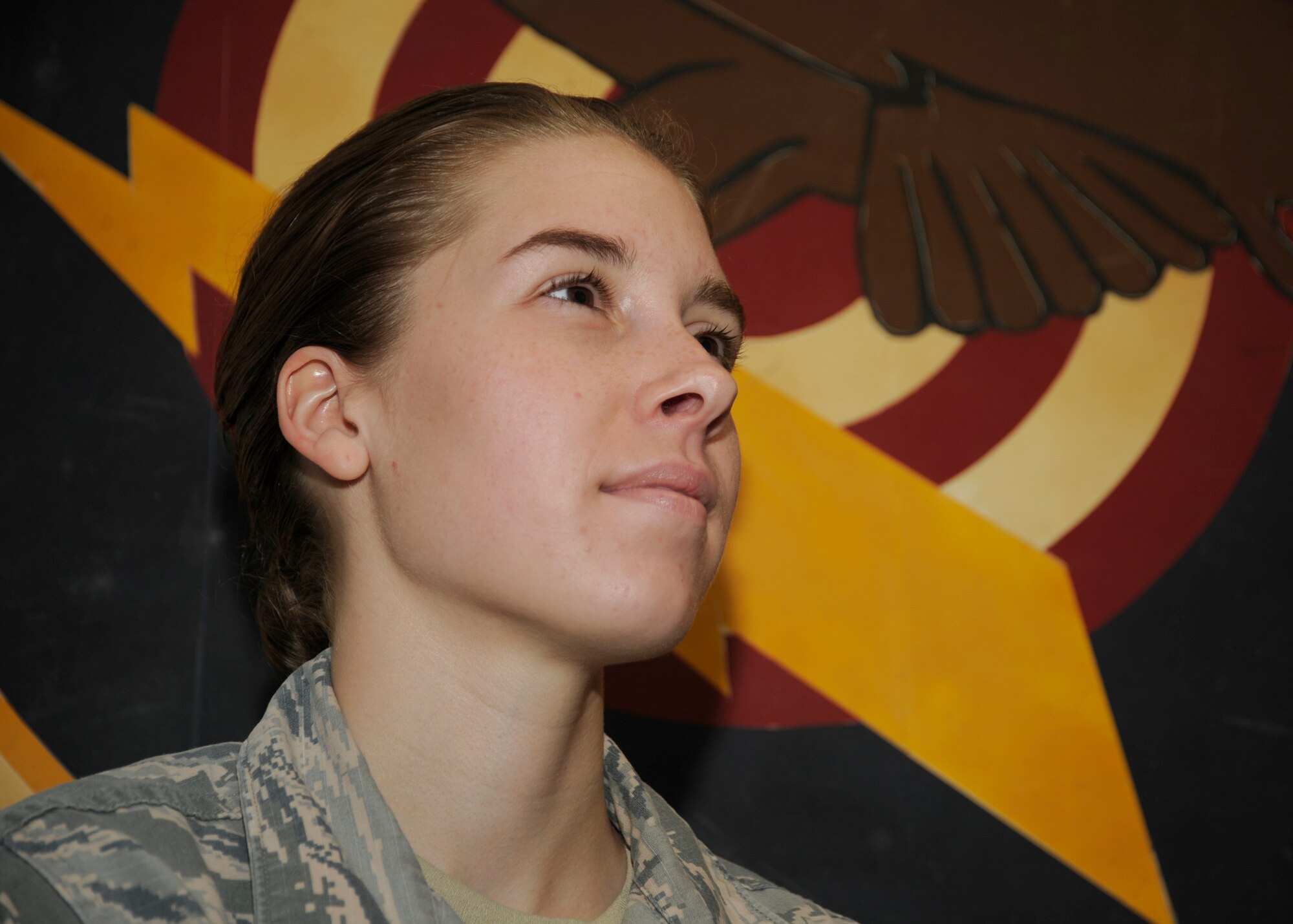 Airman 1st Class Rachel Jones from the 81st Range Control Squadron stands for a photo in front of the 81st’s squadron patch at Tyndall Air Force Base, Fla., July 27, 2016. Jones was selected by her leadership as an outstanding performer. (U.S. Air Force photo by Senior Airman Solomon Cook/Released)