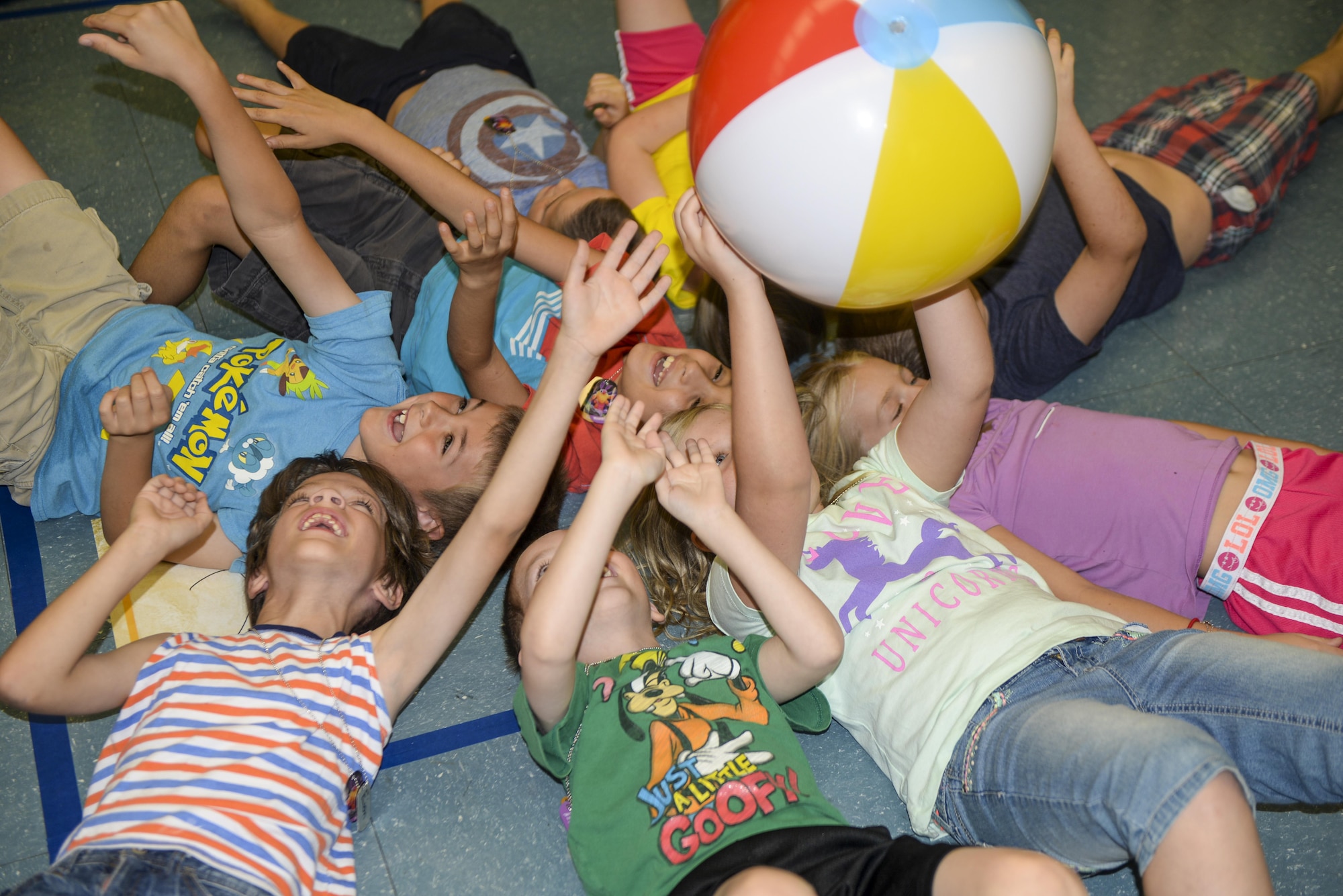 A group of children attending the base chapel’s vacation bible school toss a ball over their heads in an effort to keep it from hitting the ground as part of a game at Holloman Air Force Base, N.M., on July 19. Children attending the VBS program participate in a variety of activities, ranging from science experiments to arts and crafts. (U.S. Air Force photo by Amn Alexis P. Docherty/released) 