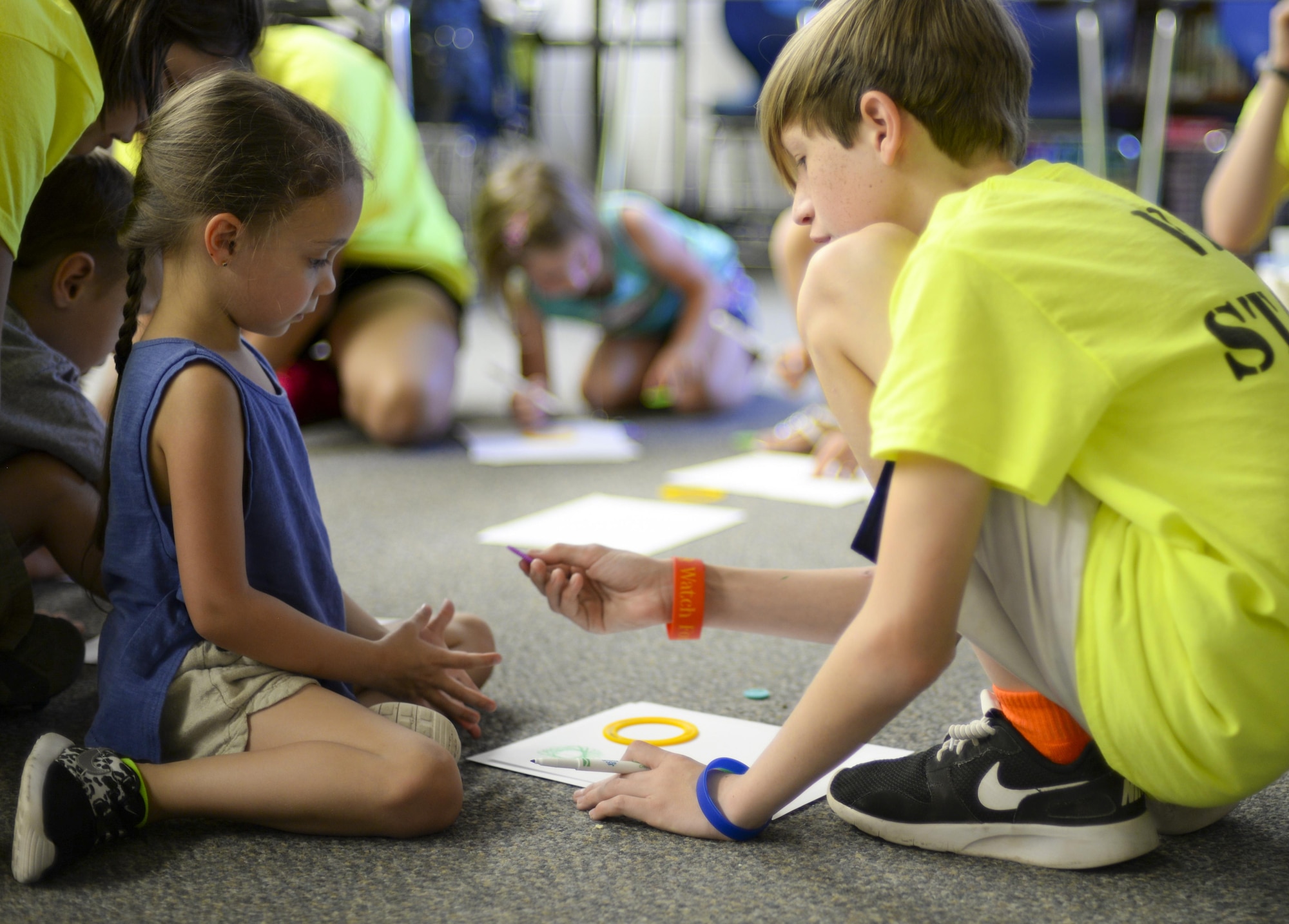 Will, a volunteer at the base chapel’s vacation bible school, helps Myla, a child attending the VBS program, during an art and crafts activity at Holloman Air Force Base, N.M., on July 20. Holloman Chapel’s vacation bible school utilized the aid of 64 volunteers this year and served over 100 children. (Last names are being withheld due to operational requirements. U.S. Air Force photo by Amn Alexis P. Docherty/released) 