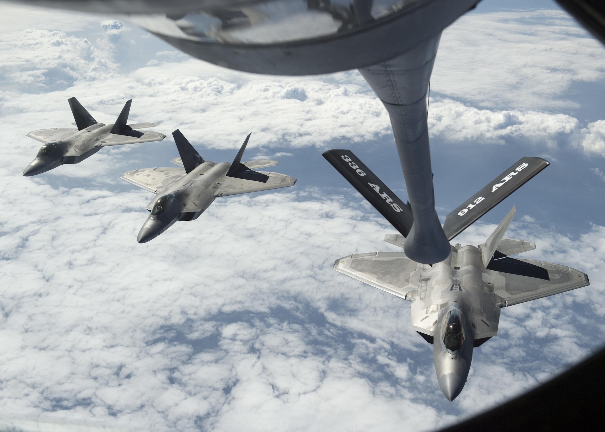 Three U.S. F-22 Raptors from the 199th Fighter Squadron and the active-duty 19th Fighter Squadron await refueling from a KC-135R Stratotanker operated by 465th Air Refueling Squadron from Tinker Air Force Base, Oklahoma, during Rim of the Pacific 2016 over Joint Base Pearl Harbor-Hickam, Hawaii, July 26, 2016. (U.S. Navy photo by Mass Communication Specialist 2nd Class Gregory A. Harden II)