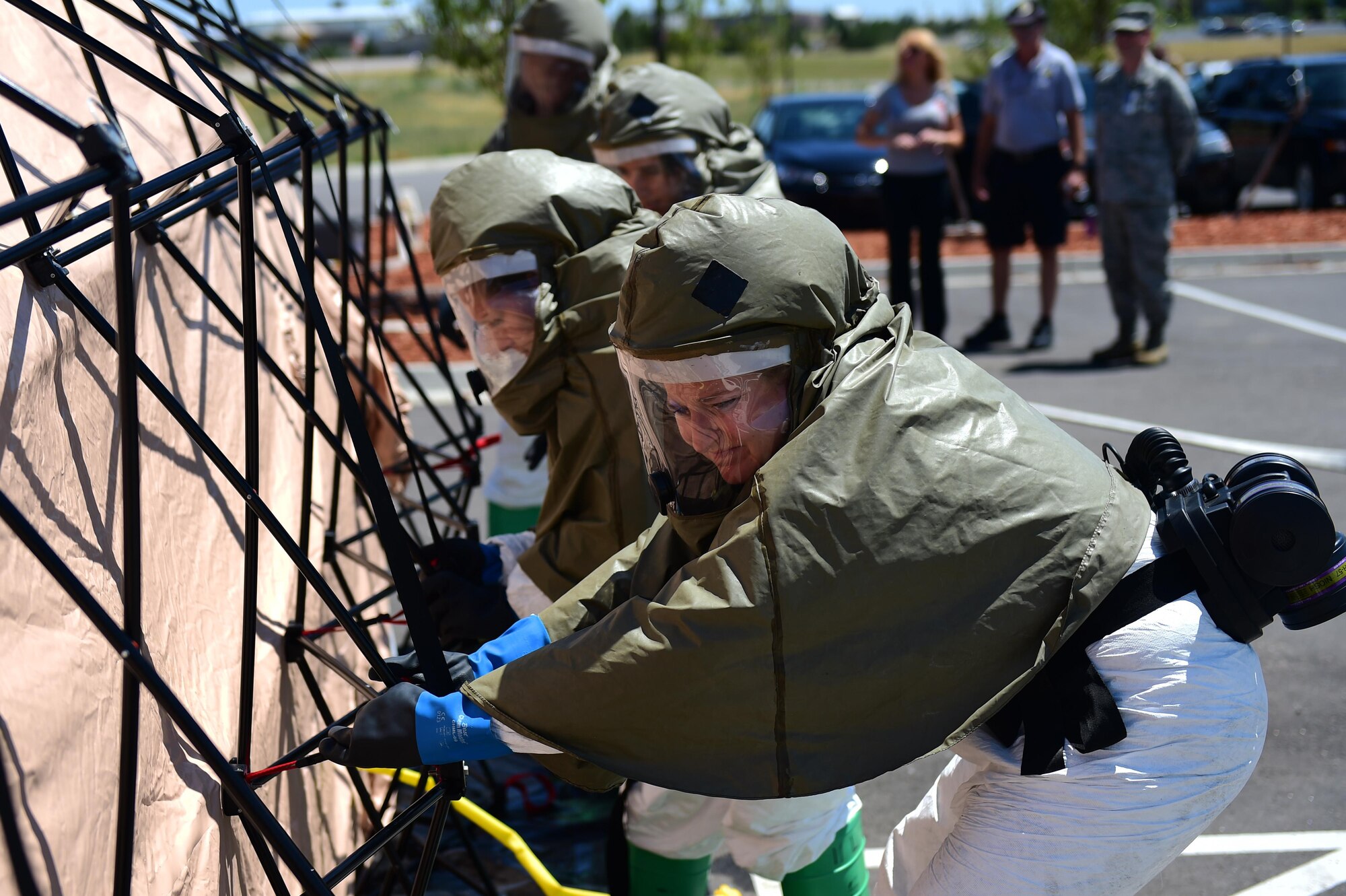 Members of the 460th Medical Group in-place patient decontamination triage and manpower/security team secure a decontamination tent July 21, 2016, during a simulated exercise on Buckley Air Force Base, Colo. The exercise had many learning points for the team, including identification of contaminants, equipment set-up and a detailed understanding of the whole decontamination process. (U.S. Air Force photo by Airman 1st Class Gabrielle Spradling/Released)