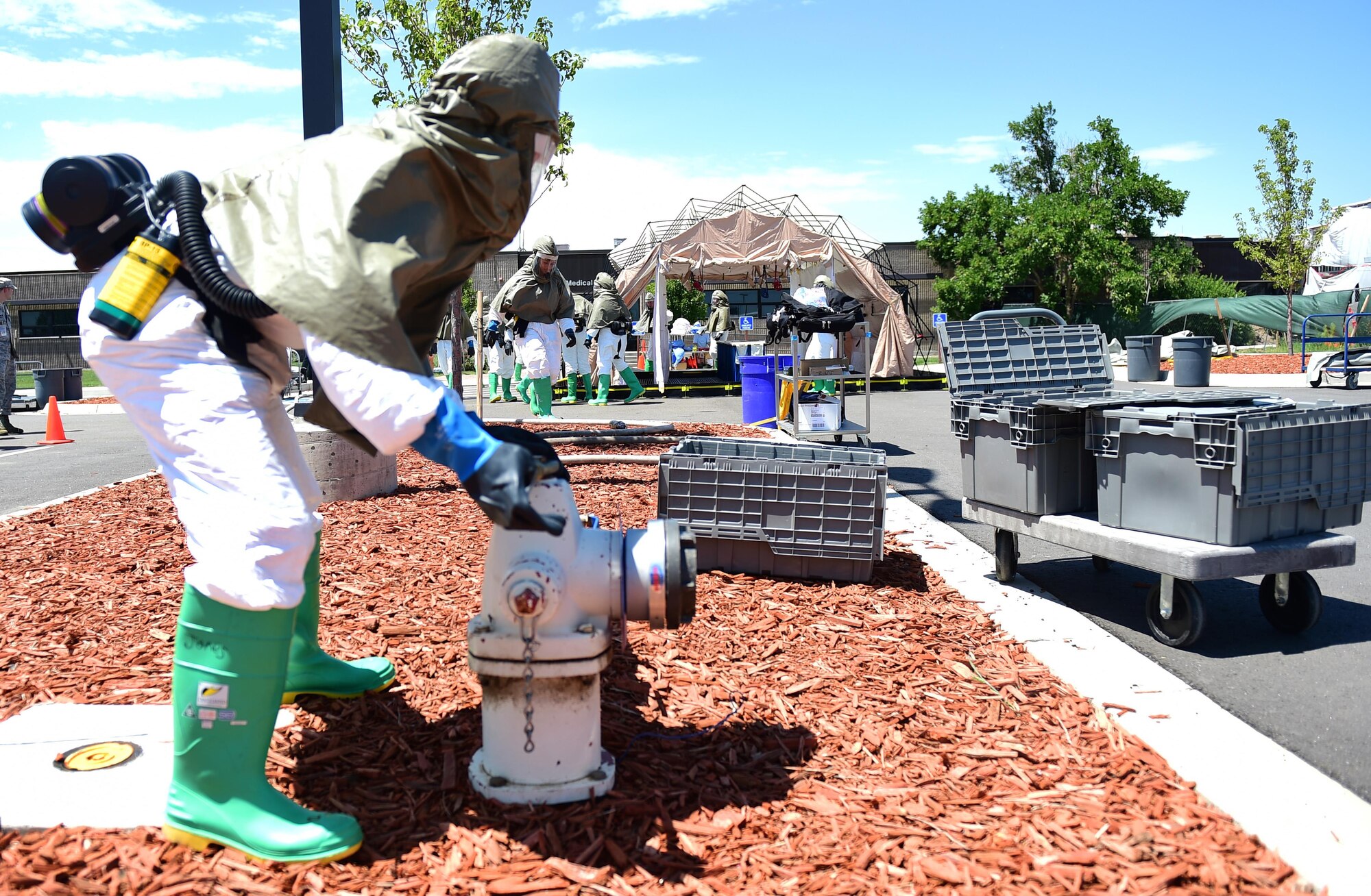 A member of the 460th Medical Group in-place patient decontamination triage and manpower/security team turns on a fire hydrant July 21, 2016, during a simulated exercise on Buckley Air Force Base, Colo. The team received 16 hours of instruction and training that not only provided them with the know-how to decontaminate patients, but also allowed them to understand the importance of the material they were learning. (U.S. Air Force photo by Airman 1st Class Gabrielle Spradling/Released)
