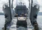 (July 27, 2016) - U.S. Army Spc. Michael Breneman signals to a Japan Ground Self Defense Force light armored vehicle during an on load evolution aboard U.S. Army Runnymede-class landing craft utility USAV Coamo (LCU 2014) at Commander, U.S. Fleet Activities Sasebo, Japan, July 27, 2016. This on load is part of the first-ever point-to-point shipment of JGSDF vehicles aboard U.S. military vessels. The JGSDF personnel and equipment will take part in Rising Thunder, an annual bilateral U.S. Army-JGSDF exercise held at Yakima Training Center, Wa. 