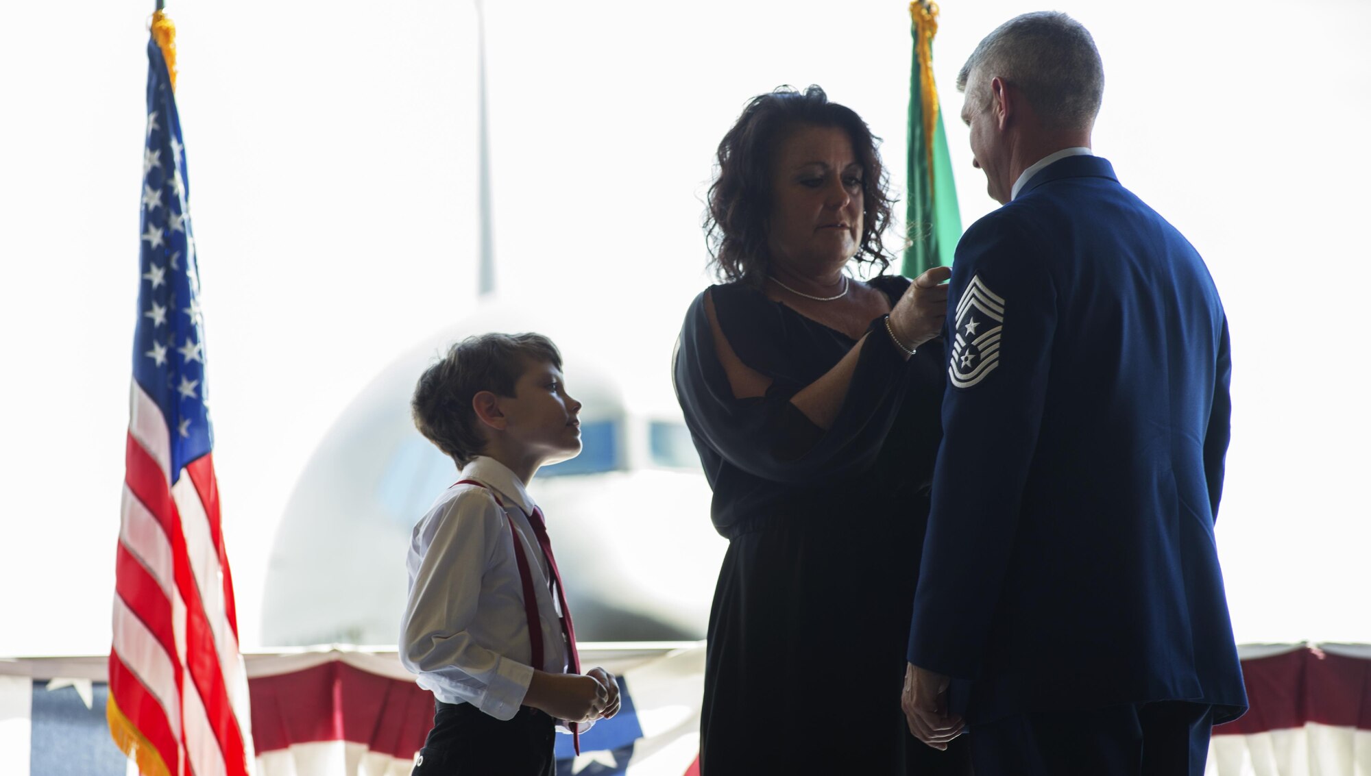 Chief Master Sgt. Christian Pugh, 92nd Air Refueling Wing command chief, is presented with a retirement pin by his family during his retirement ceremony July 27, 2016, at Fairchild Air Force Base, Wash. While stationed at Fairchild Pugh was not accompanied by his family. After retirement he will be going to San Antonio, to spend time with them. (U.S. Air Force photo/Airman 1st Class Sean Campbell)