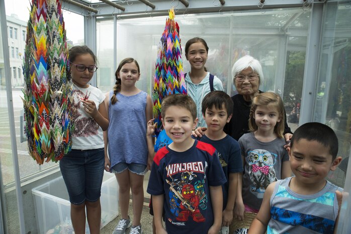 Kikuko Shinjo, better known as ‘Shinjo-Sensei,’ an 89 year-old native of Iwakuni and survivor of the atomic bombing in Hiroshima during World War II, poses with children from Marine Corps Air Station Iwakuni at the Children’s Peace Monument at Hiroshima Peace Memorial Park, Japan, July 15, 2016. Shinjo invited a group of MCAS Iwakuni residents to help her donate 1,000 paper cranes, which she folded, to the Children’s Peace Monument at Hiroshima Peace Memorial Park as a symbol for peace. (U.S. Marine Corps photo by Lance Cpl. Donato Maffin)