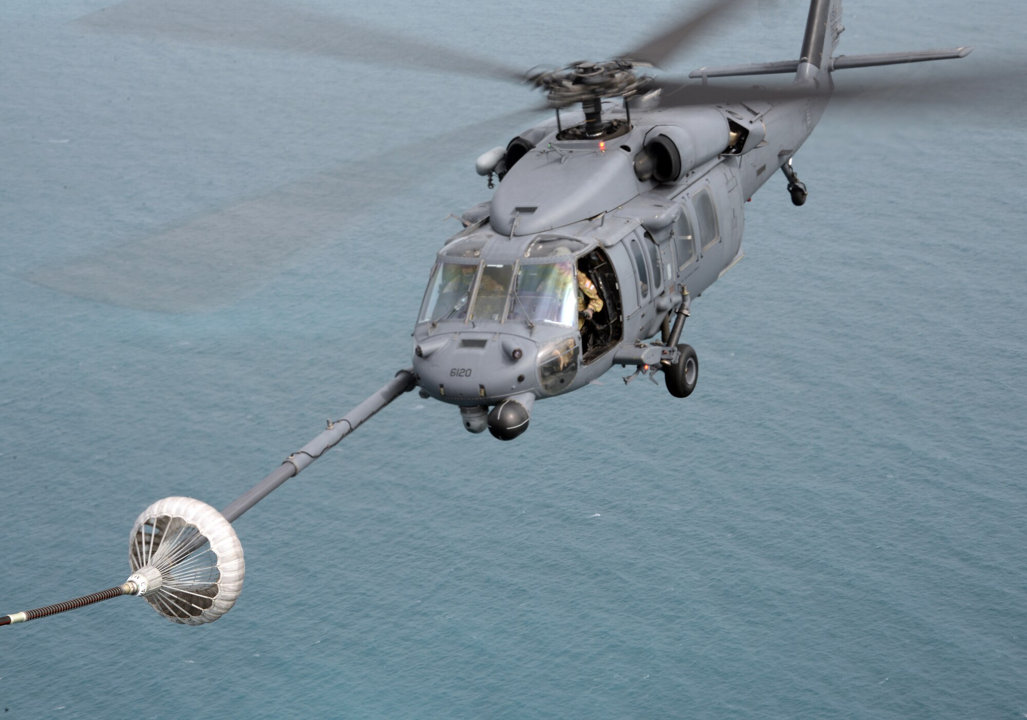 An HH-60 Pilot with the 129th Rescue Wing successfully latches on to the drogue of an MC-130P Combat Shadow to begin air refueling during a training exercise for operation Angel Reign in Townsville Australia, June 30, 2016. (U.S. Air National Guard photo by Senior Airman Zachiah Roberson/released)