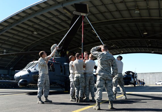 Members of the 129th Rescue Wing maintenance squadron unfold the main blades of an HH-60 Pavehawk shortly after its arrival at Royal Australian Air Force base Townsville for operation Angel Reign, June 28, 2016. The 129th MXS unfolded a total of two helicopters which were later used for multiple exercise missions alongside pararescuemen.   (U.S. Air National Guard photo by Senior Airman Zachiah Roberson/released)