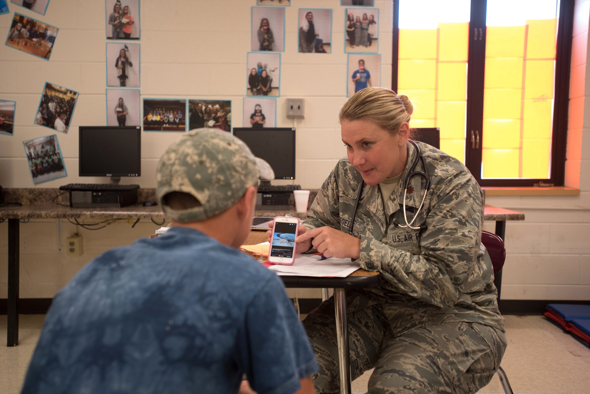 U.S. Air Force Maj. Lauren Voegel, a flight surgeon for the Kentucky Air National Guard’s 123rd Medical Group, talks to a Western Kentucky resident about her previous deployments while waiting to see patients during Bluegrass Medical Innovative Readiness Training at Carlisle County High School in Bardwell, Ky., July 20, 2016. The Kentucky Air National Guard, U.S. Navy Reserve and other military units are teaming with the Delta Regional Authority to offer medical and dental care at no cost to residents in Bardwell and two other Western Kentucky locations from July 18 to 27 as part of the training event. (U.S. Air National Guard photo by Master Sgt. Phil Speck)