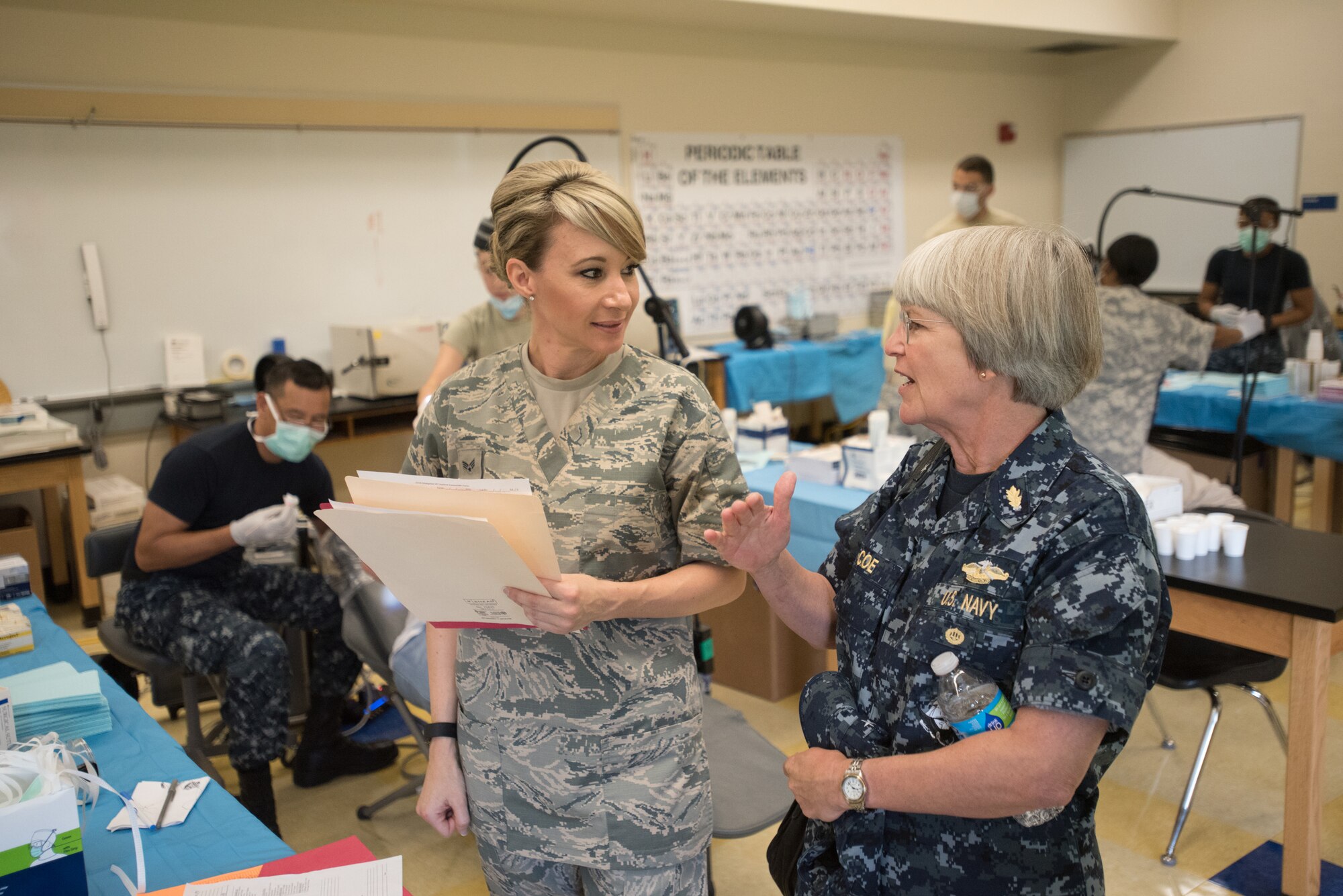 U.S. Navy Rear Adm. Priscilla Coe, deputy chief of staff for the U.S. Navy Bureau of Medicine and Surgery and deputy chief of the Navy Reserve Dental Corps, speaks with U.S. Air Force Senior Airman Kristin Bentley, a dental assistant from the Utah Air National Guard’s 151st Medical Group, about dental care being provided to patients at Paducah Tilghman High School in Paducah, Ky., on July 23, 2016, as part of Bluegrass Medical Innovative Readiness Training. The Kentucky Air National Guard, U.S. Navy Reserve and other military units are teaming with the Delta Regional Authority to offer medical and dental care at no cost to residents in Paducah and two other Western Kentucky locations from July 18 to 27 as part of the training event. (U.S. Air National Guard photo by Master Sgt. Phil Speck)