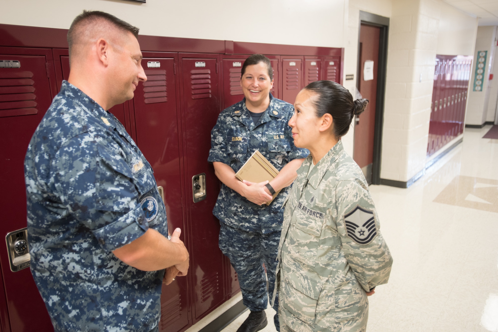 U.S. Navy Master Chief Jeff Williamson (left), command master chief of the Navy Reserve Expeditionary Medical Facility Great Lakes 1, and U.S. Navy Chief Hospital Corpsman Ann Carlson, Navy senior enlisted leader from Navy Reserve Expeditionary Medical Facility Great Lakes Detachment V, present a coin of excellence to U.S. Air Force Master Sgt. Marie Plaza, health systems technician from the Kentucky Air National Guard’s 123rd Medical Group, at Carlisle County High School in Bardwell, Ky., July 23, 2016, during Bluegrass Medical Innovative Readiness Training. The Kentucky Air National Guard, U.S. Navy Reserve and other military units are teaming with the Delta Regional Authority to offer medical and dental care at no cost to residents in Bardwell and two other Western Kentucky locations from July 18 to 27 as part of the training event. (U.S. Air National Guard photo by Master Sgt. Phil Speck)