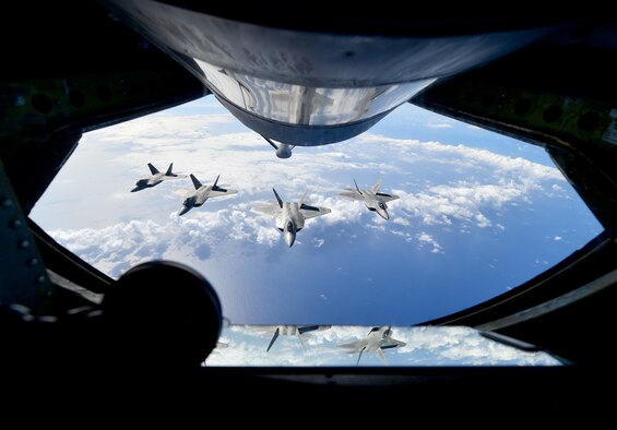 A view from the refueling pod of a KC-135R operated by Citizen Airmen with the 465th Air Refueling Squadron (ARS) deployed from Tinker Air Force Base, Oklahoma as four F-22 Raptors fly in a formation following an aerial refueling. During the flight, the Okies of the 465th ARS offloaded 42,700 lbs. of fuel to the fighters. The Hawaiian Raptors are made up of a combination of the 119th Fighter Squadron, Hawaii Air National Guard and the 19th Fighter Squadron, Joint Base Pearl Harbor Hickam, Hawaii. (U.S. Air Force photo by Tech. Sgt. Lauren Gleason)