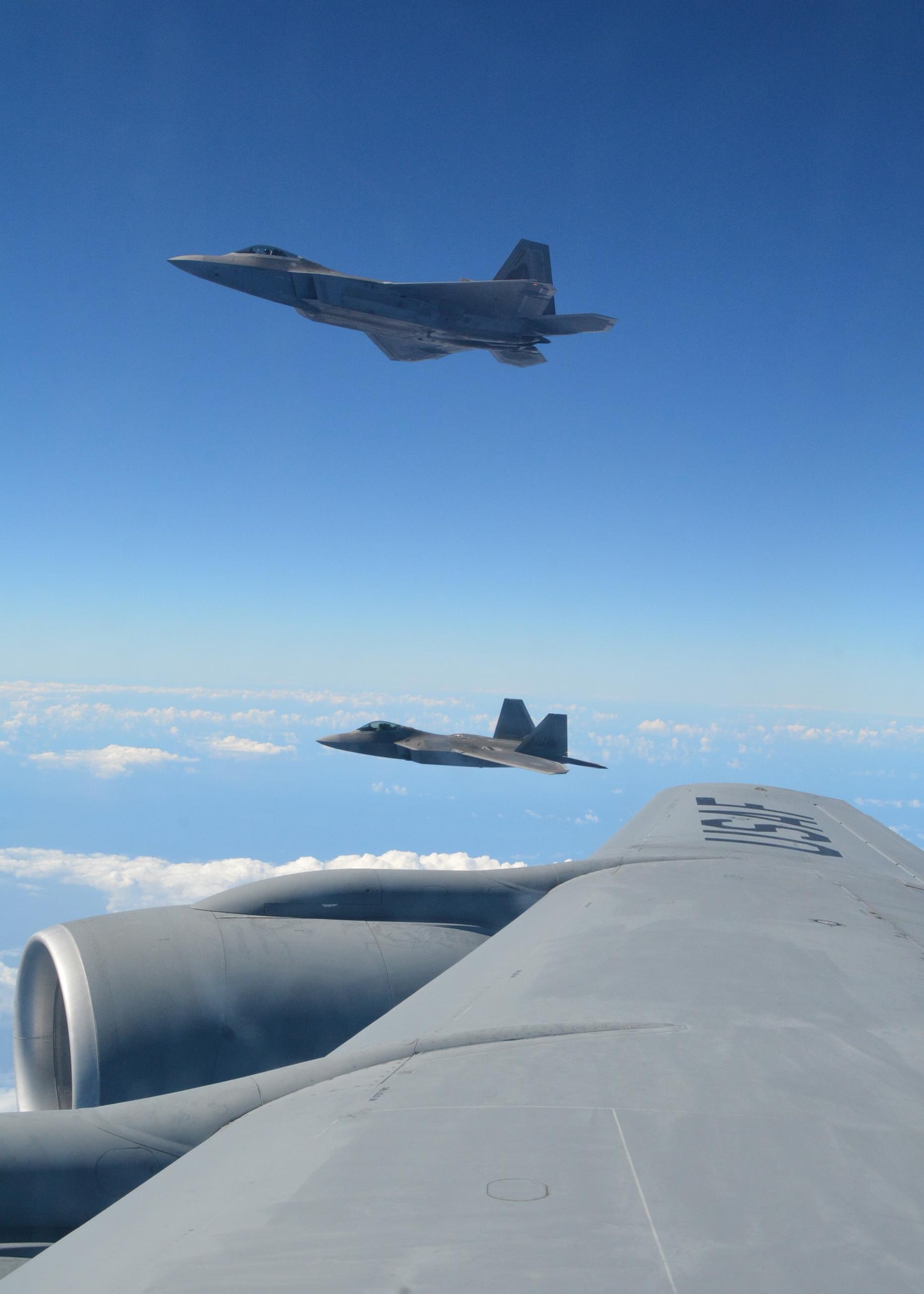 Two Hawaiian F-22 Raptors fly alongside the wing of a KC-135R Stratotanker flown by Citizen Airmen of the 465th Air Refueling Squadron, Tinker Air Force Base, Oklahoma.   Since arriving in Hawaii July 7, the 465th ARS along with other Reserve units have offloaded over 2 million pounds of fuel to U.S. and Royal Canadian aircraft during RIMPAC 2016. (U.S. Air Force video by Tech. Sgt. Lauren Gleason)