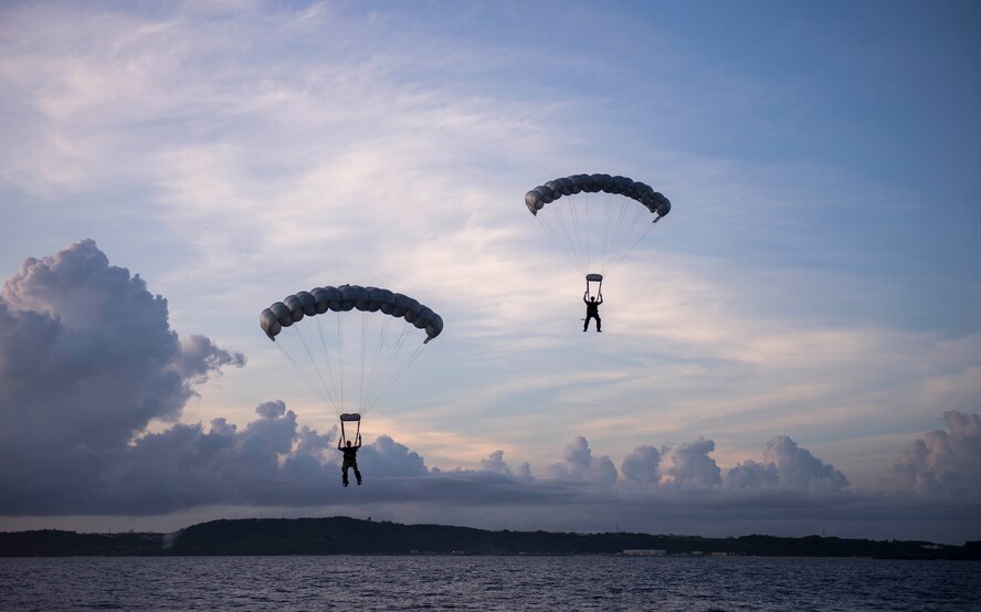 Two pararescuemen, from Kadena Air Base’s 31st Rescue Squadron, parachute into the Pacific Ocean during a rescue training scenario June 29, 2016. Pararescuemen train both night and day to maintain critical skills for their missions. (U.S. Air Force photo by Senior Airman Omari Bernard)