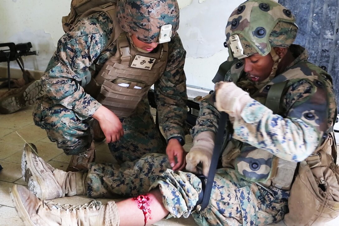 U.S. Navy hospitalman 2nd Class Jonathan Rivas, (left), with Charlie Company, 1st Battalion 8th Marine Regiment, Special Purpose Marine Air-Ground Task Force-Crisis Response-Africa assess a simulated wound on U.S. Marine Corps Lance Cpl Zachary C. Hill, (right), a team leader, during a combined arms attack aboard Camp Sissonne, France, June 21, 2016. CENZUB provided SPMAGTF-CR-AF Marines with the ability to maintain their proficiencies in urban combat and integrate with French personnel and assets in a realistic scenario. (U.S. Marine Corps photo by Sgt. Kassie McDole/Released.) 