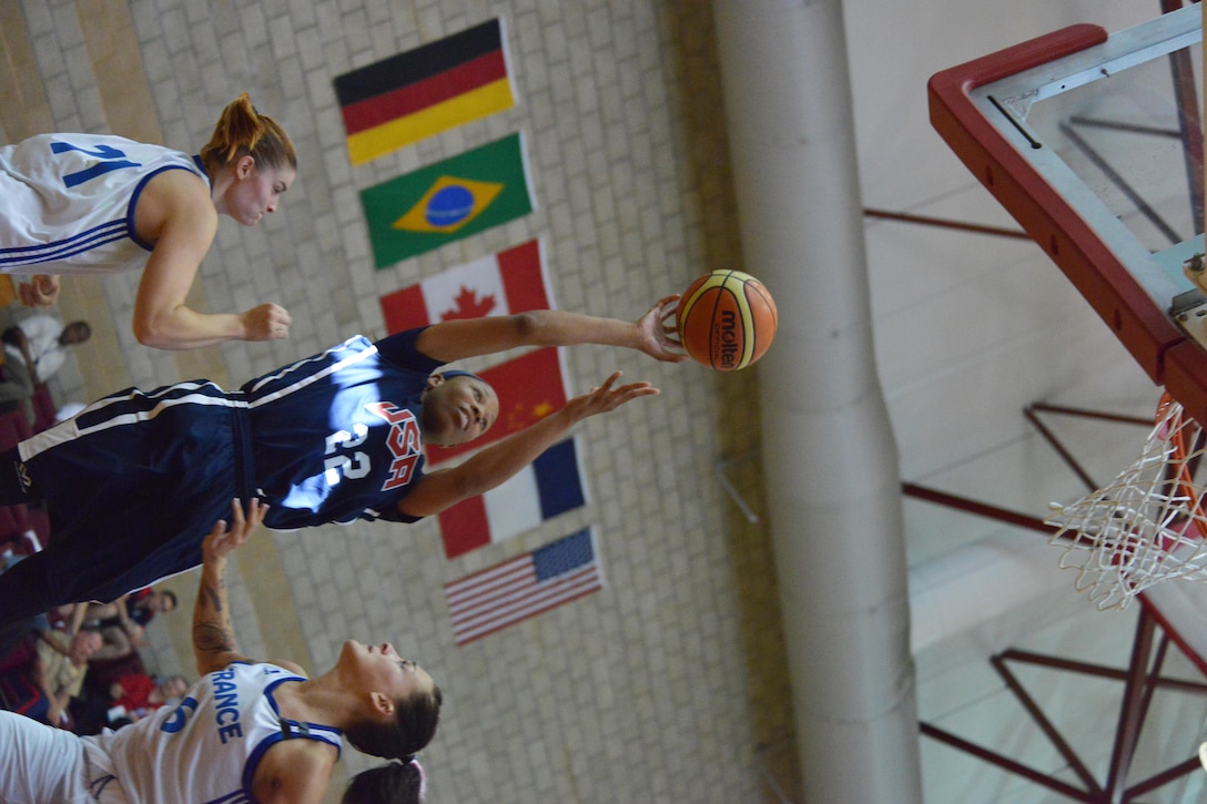 Despite being double-teamed, Seaman Jameika Hoskins of the USS Rushmore takes it to the hoop during USA's 85-53 win over France in day two of the CISM Women's Basketball Championship at Camp Pendleton, Calif.