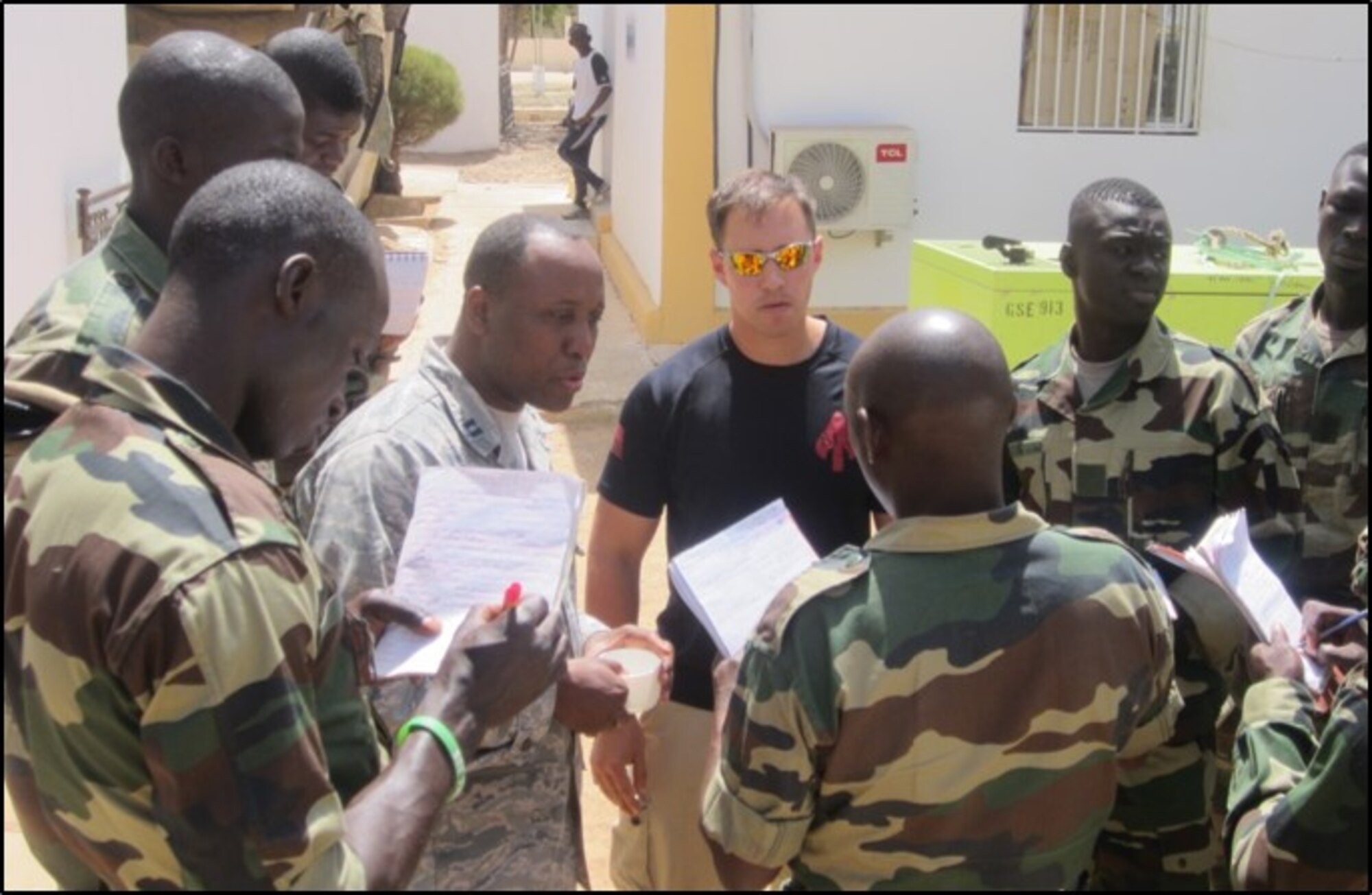 Air Force Capt. Patrick Mudimbi (left center) translates for Marine Corps Chief Warrant Officer Jonathan Ross in Senegal as they train Senegalese soldiers how to interrogate a potential informant or source.