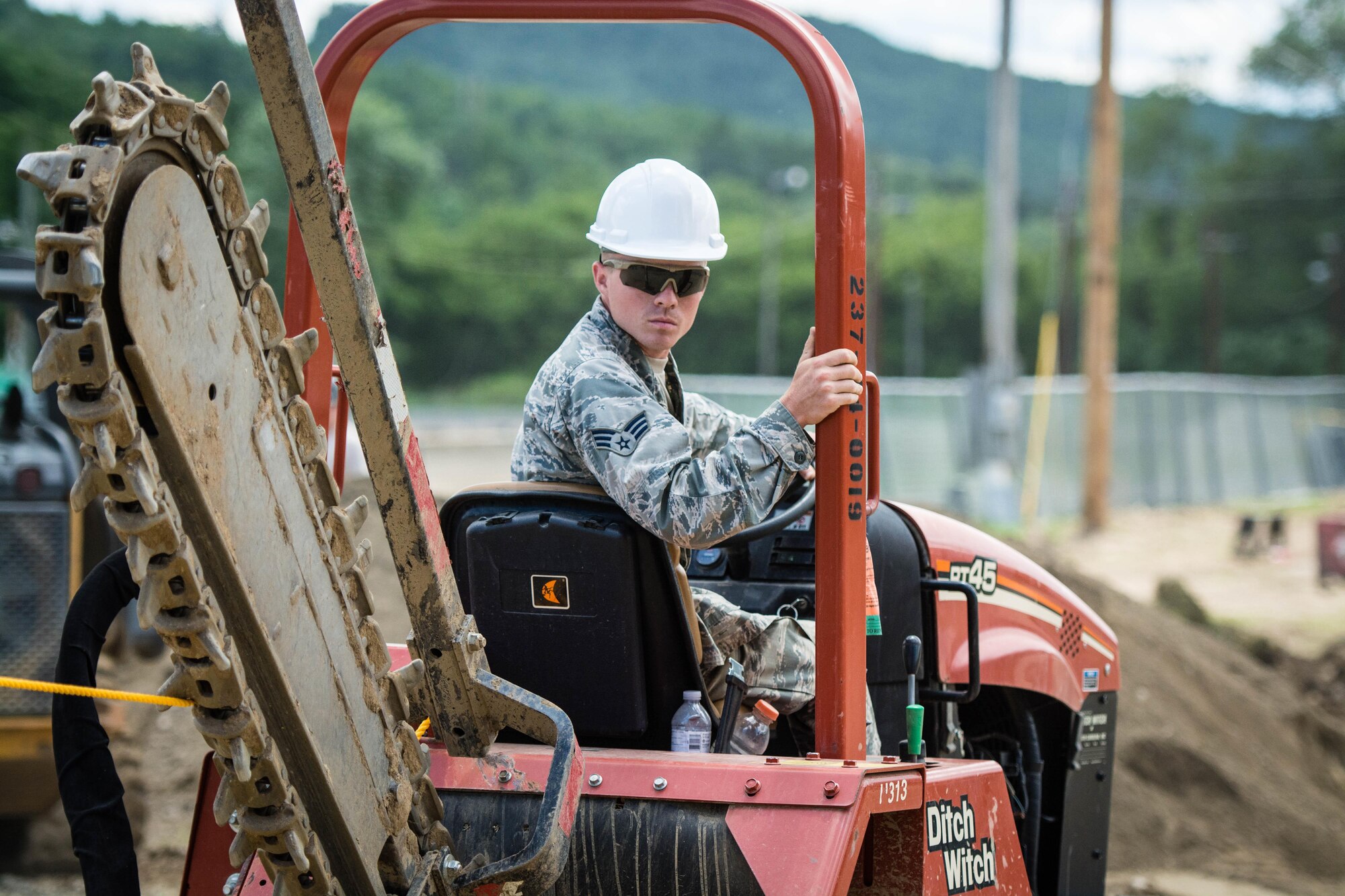 Senior Airman Justin Whittington assists in the installation of underground power lines using a trencher, Jul. 21, 2016 at the Chenango County fairgrounds in Norwich, New York. Whittington joined fellow Reserve Airmen from the 512th Civil Engineering in an Innovative Readiness Training project July 11-22. The IRT program provides civil military affairs training and skills to service members and units while supporting local communities across the United States. For this particular project, 512th CES Airmen joined two other civil engineering squadrons from the Air Force Reserve Command in providing upgrades to the fairgrounds. (U.S. Air Force photo/1st Lt. Steve Lewis)