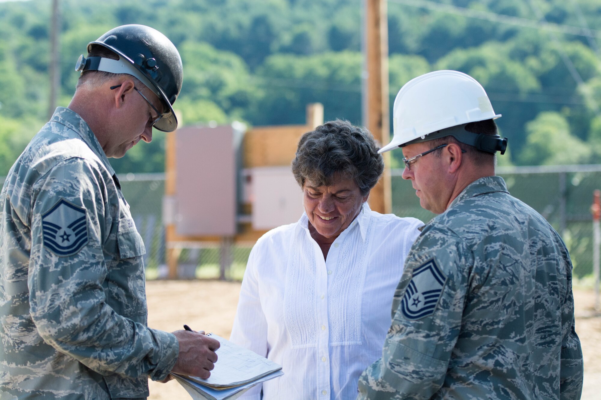 Mary Weidman, Chenango County Agricultural Society president, discusses construction plans for a new fairgrounds office building in Norwich, New York, with Senior Master Sgt. Calvin Keyser (right), 512th Civil Engineer Squadron, Dover Air Force Base, Del., and Master Sgt. Douglas Schmidt, 434th Civil Engineer Squadron, Grissom Air Reserve Base, Ind., at the Chenango County fairgrounds in Norwich, New York, Jul. 22, 2016. Weidman and the agriculture society gained military support for fairgrounds infrastructure projects through the Department of Defense's Innovative Readiness Training Program. (U.S. Air Force photo/1st Lt. Steve Lewis)