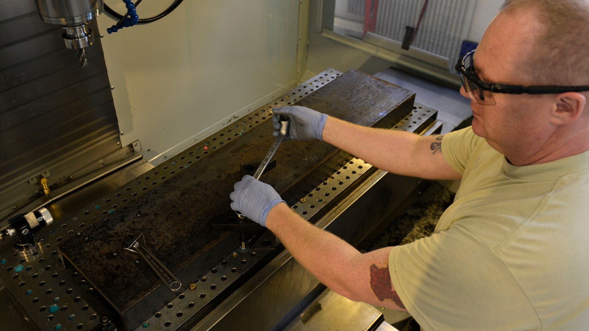 Master Sgt. Kyle Eickhoff, 31st Maintenance Squadron Metals Technology section chief, clamps a metal part into place in a computer numeric control machine, July 27, 2016, at Aviano Air Base, Italy. A CNC machine enables the metals technology Airmen to make precise cuts in metal parts. (U.S. Air Force photo by Airman 1st Class Cary Smith/Released)