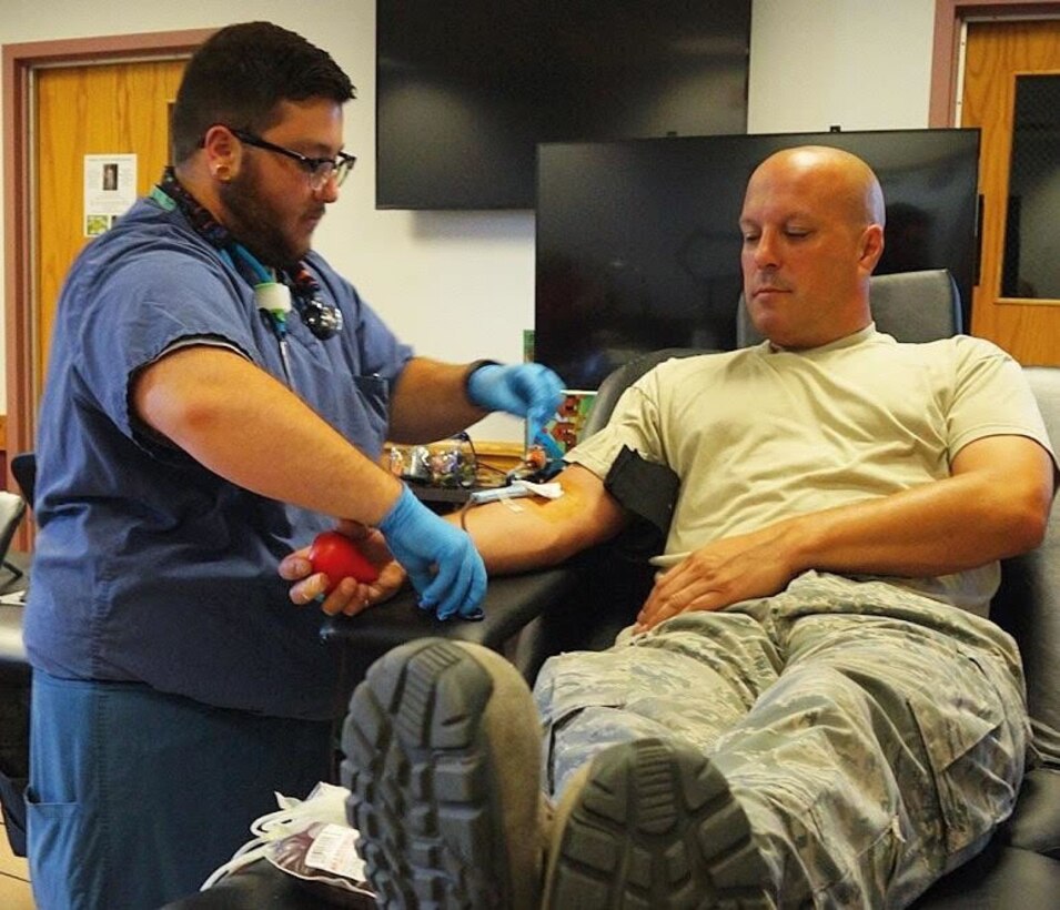 Phlebotomist Jay Cannata of Kenmore, N.Y. checks on Master Sgt. Doug Kalota, crew chief, 914 Aircraft Maintenance Group as he donates blood on Tuesday, July 19, 2016, at Niagara Falls Air Reserve Station, Niagara Falls, N.Y. With more than 20 donors, this was the most successful blood drive on base this year. (U.S. Air Force photo by Staff Sgt. Richard Mekkri/released)