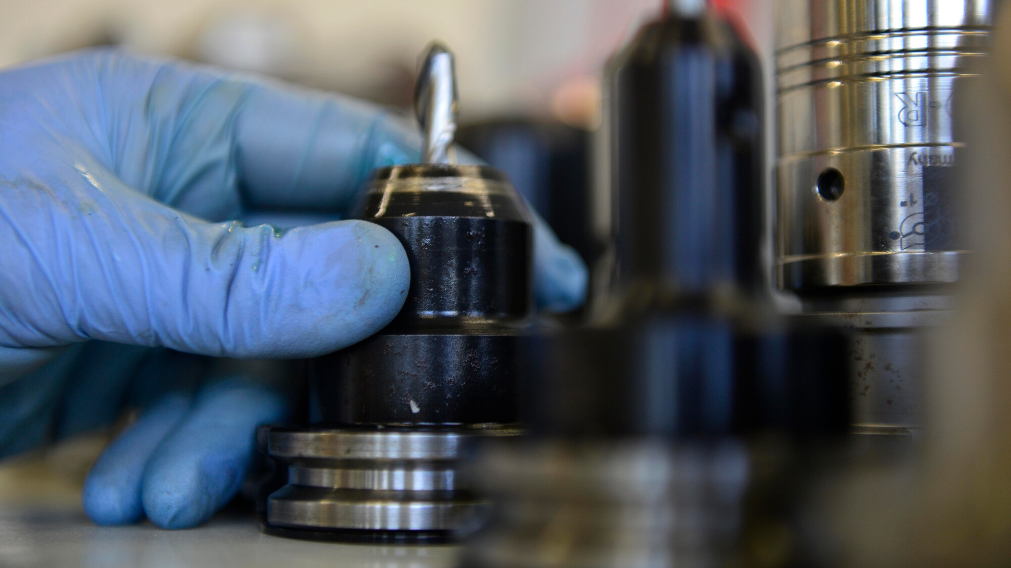 Master Sgt. Kyle Eickhoff, 31st Maintenance Squadron Metals Technology section chief, selects a computer numeric control machine drill bit, July 27, 2016, at Aviano Air Base, Italy. A CNC machine cuts and drills parts for Airmen to build metal structures for base operations. (U.S. Air Force photo by Airman 1st Class Cary Smith/Released) 