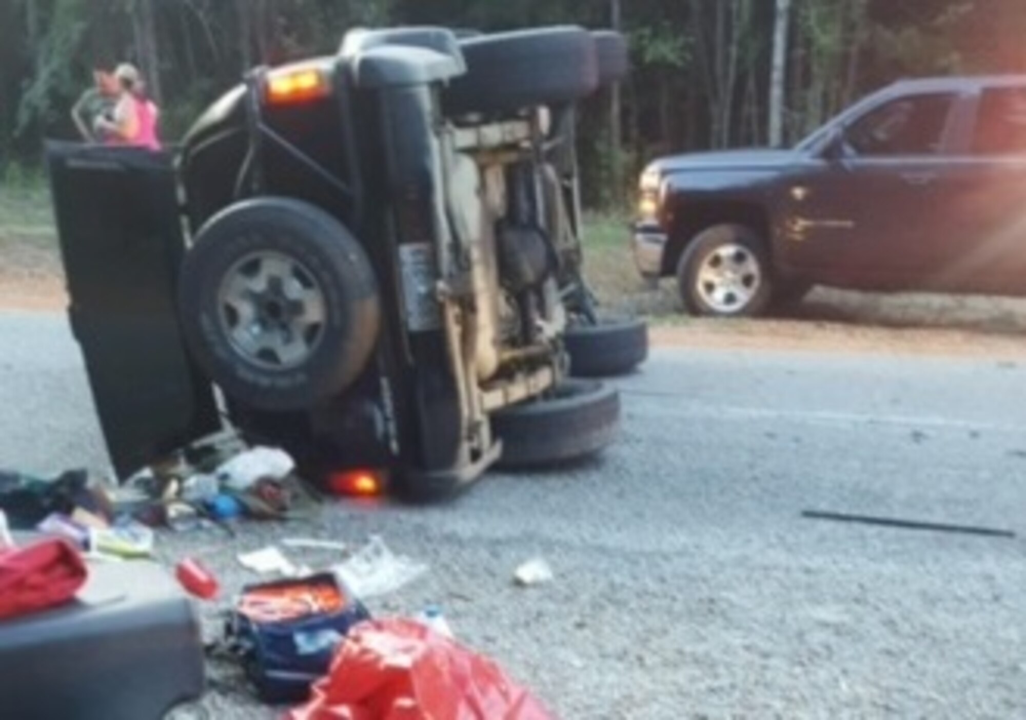 A toppled vehicle lays on its side on Land Road after the driver and two children passengers were saved by Senior Airman Ramon Curtis, 14th Operations Support Squadron weather forecaster, and 2nd Lt. Christopher Kowalski, 14th Student Squadron student pilot, July 24 in Lowndes County, Mississippi.  (Courtesy Photo)