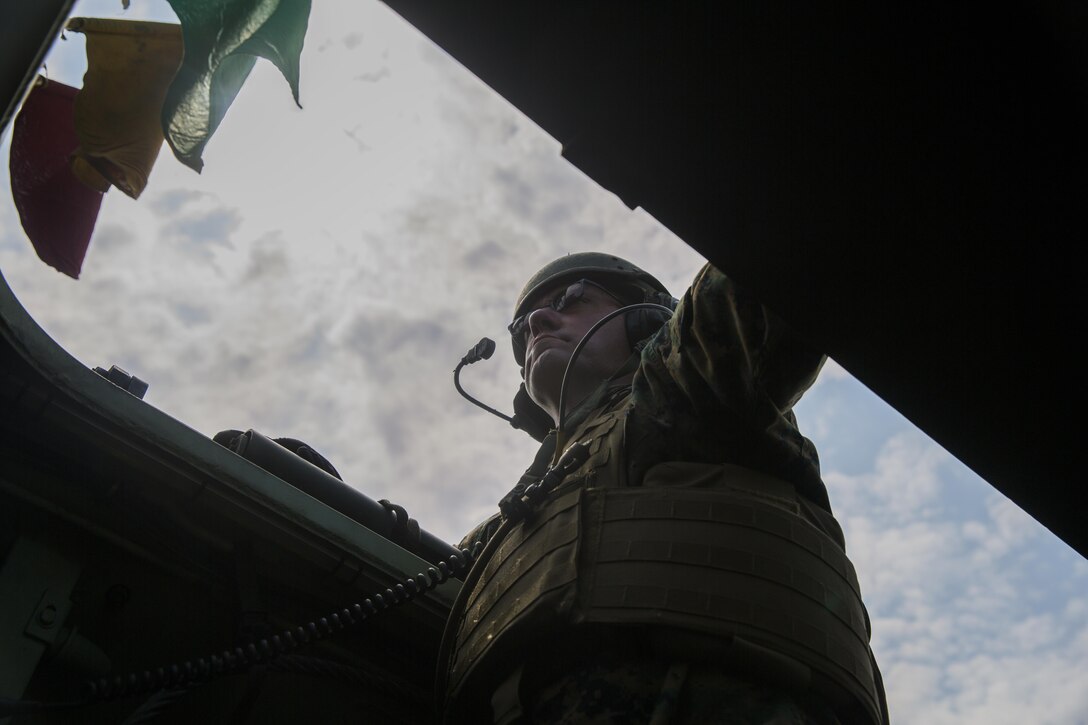 Chief Warrant Officer 5 Christian Wade, the 2nd Marine Division gunner, stares out the top of an assault amphibious vehicle during a live-fire gunnery range at Camp Lejeune, N.C., July 27, 2016. Marines with Alpha Company, 2nd Assault Amphibian Battalion spent the day refining their shooting skills by shooting the M-2 .50 caliber machine gun as well as the MK-19 40mm grenade launcher at various distances.