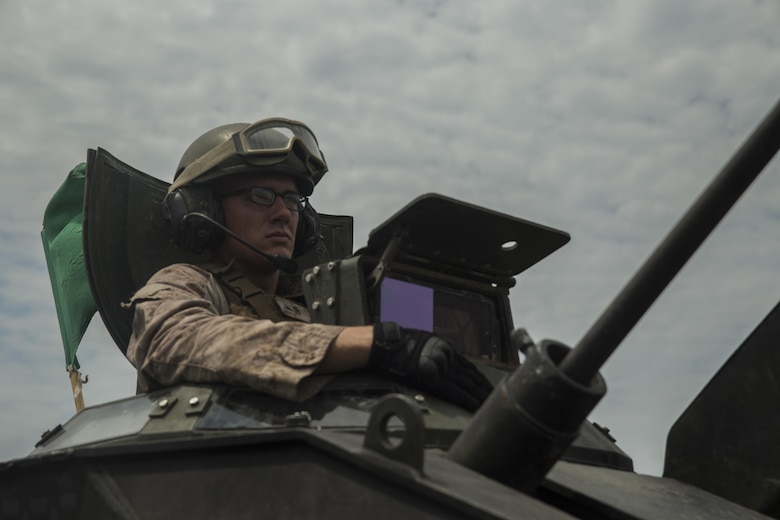 Lance Cpl. Kevin Christ, a crewman with Alpha Company, 2nd Assault Amphibian Battalion, spots targets downrange during a live-fire gunnery range at Camp Lejeune, N.C., July 27, 2016. With a max possible score of 1,000, Marines must fire through ten separate engagements compiling a score of 700 to pass.