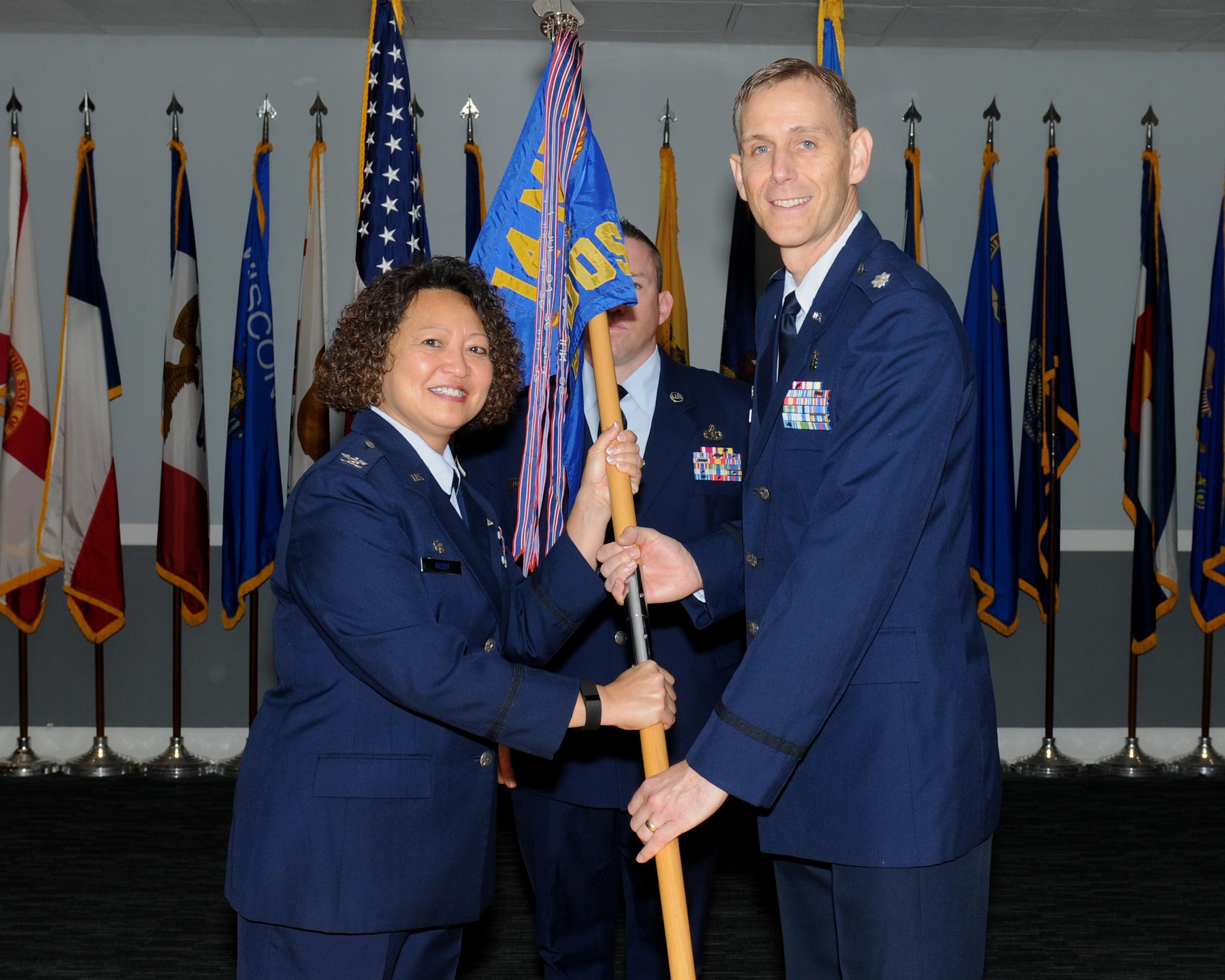 Col. Imelda Reedy, 14th Medical Group Commander, passes the 14th Medical Operations Squadron guidon to Lt. Col. Matthew Ostler, the new 14th MDOS Commander, during a change of command ceremony July 21 at Columbus Air Force Base, Mississippi. (U.S. Air Force photo/Melissa Doublin)