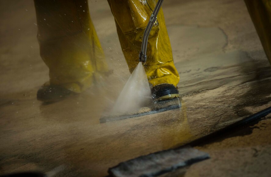 An Airman from the 5th Aircraft Maintenance Squadron rinses his sponge during a BUFF wash at Minot Air Force Base, N.D., July 25, 2016. Specialized cleaning solutions are used to prevent corrosion and degradation to the aircraft’s frame. (U.S. Air Force photo/Senior Airman Apryl Hall)