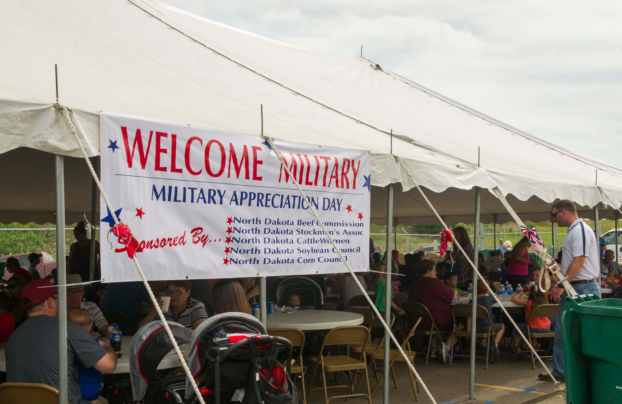 Military members and their families eat lunch at the beef picnic during Military Appreciation Day at the North Dakota State Fair in Minot, N.D., July 26, 2016. In addition to the free lunch, service members also had a discounted entry free and were able to ride rides free of charge. (U.S. Air Force photo/Senior Airman Apryl Hall)