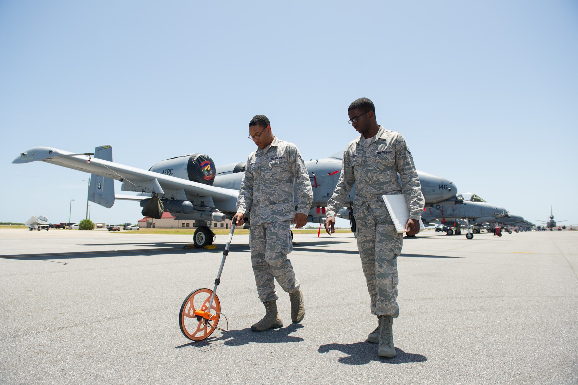 Senior Airmen Damon Sheperd, airfield management operations supervisor, and Henson Greene, airfield management shift lead, measure distances between aircraft to ensure there is adequate wingtip clearance at Patrick Air Force Base, Fla., July 28, 2016. The Airmen are members of the 45th Operations Support Squadron who ensure the airfield is safe for all flying operations with routine checks of the flightline area, which includes verifying adequate wing tip clearance that prevents aircraft from being too close to each other or equipment parked nearby.   During the month of July they helped the 45th Space Wing host visiting A-10 Thunderbolt IIs from 924th Fighter Group, stationed at Davis-Monthan Air Force Base, Arizona, who were here to train with the 920th Rescue Wing's helicopter squadron, the 301st Rescue Squadron, July 18 to 29, 2016. (U.S. Air Force photos/Benjamin Thacker)