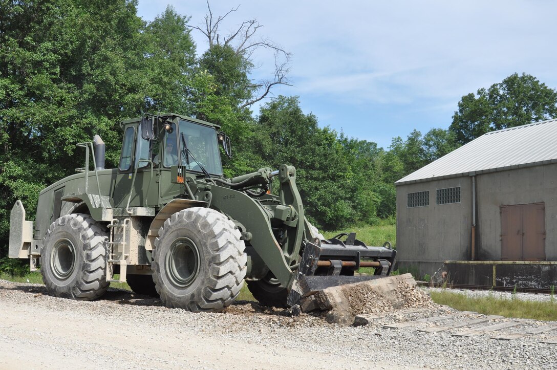 U.S. Army Reserve Soldiers of the 983rd Engineering Battalion worked on five construction projects designed to improve infrastructure during the unit’s annual training hosted by Crane Army Ammunition located on Naval Support Activity Crane Activity. The 983rd Engineering Battalion’s main line of effort during their time at Crane Army involved the rails to road project. In total the project required the removal of over 2,000 feet of railroad tracks. The project, a unique mission that the Soldiers had not previously been exposed to, involved fifteen personnel and took seven days to complete. “We’ve been working closely with CAAA engineers, and the Navy facilities managers, as well as the independent rail contractors here, and they have done nothing but help us and support us,” 1st Lt. Timothy Bauer said. “The uniqueness of the project is something the troops will be able to take with them anywhere.” Converting the rails to roads will provide CAAA with easier access to magazines that were previously only accessible by rail.