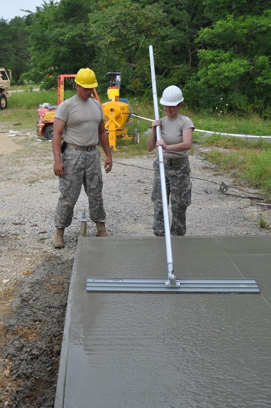 U.S. Army Reserve Soldiers of the 983rd Engineering Battalion worked on five construction projects designed to improve infrastructure during the unit’s annual training hosted by Crane Army Ammunition located on Naval Support Activity Crane Activity. After placing the concrete, Spec. Joshua Woodrum instructed 1st Lt. Dana Kimbleman on how to rake concrete. Kimbleman, one of the officers in charge of the project, experienced her first annual training project at Crane Army. “I think the project is a one of a kind opportunity. We don’t get to do this kind of work while we’re drilling so it’s good practice for deployments,” Kimbleman said. The concrete pad is part of a larger project that will provide CAAA with a more protected storage unit for munitions.