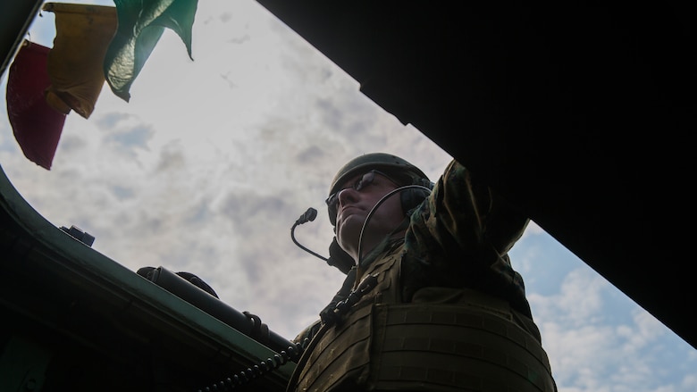 Chief Warrant Officer 5 Christian Wade, the 2nd Marine Division gunner, stares out the top of an assault amphibious vehicle during a live-fire gunnery range at Marine Corps Base Camp Lejeune, North Carolina, July 27, 2016. Marines with Alpha Company, 2nd Assault Amphibian Battalion spent the day refining their shooting skills by shooting the M-2 .50 caliber machine gun as well as the MK-19 40mm grenade launcher at various distances.