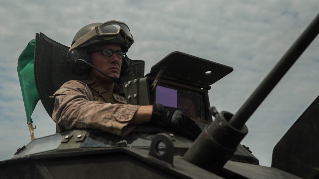 Lance Cpl. Kevin Christ, a crewman with Alpha Company, 2nd Assault Amphibian Battalion, spots targets downrange during a live-fire gunnery range at Marine Corps Base Camp Lejeune, North Carolina, July 27, 2016. With a max possible score of 1,000, Marines must fire through ten separate engagements compiling a score of 700 to pass.