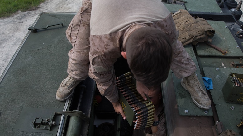 A Marine with Alpha Company, 2nd Assault Amphibian Battalion, prepares .50 caliber rounds prior to a live-fire gunnery range at Marine Corps Base Camp Lejeune, North Carolina, July 27, 2016. Individual Marines were required to engage ivan and hard targets at various ranges while determining whether to use the M-2 .50 caliber machine gun or the MK-19 40mm grenade launcher.