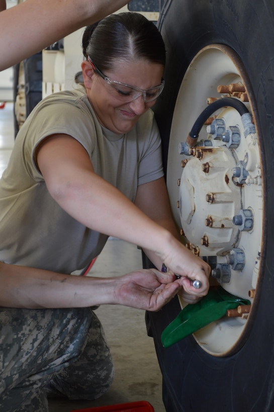 Army Reserve Spc. Brittany E. McClure, 298th Support Maintenance Company, Clearfield,
Pa., breaks an oil plug loose from a wheel assembly of a Light Medium Tactical Vehicle (LMTV)  during Platinum Wrench Annual
Exercise at Ft. McCoy, Wis., on July 27, 2016. The hands-on exercise gives Soldiers
training in maintenance procedures. (U.S. Army photo by Spc. Thomas
Watters/Released)