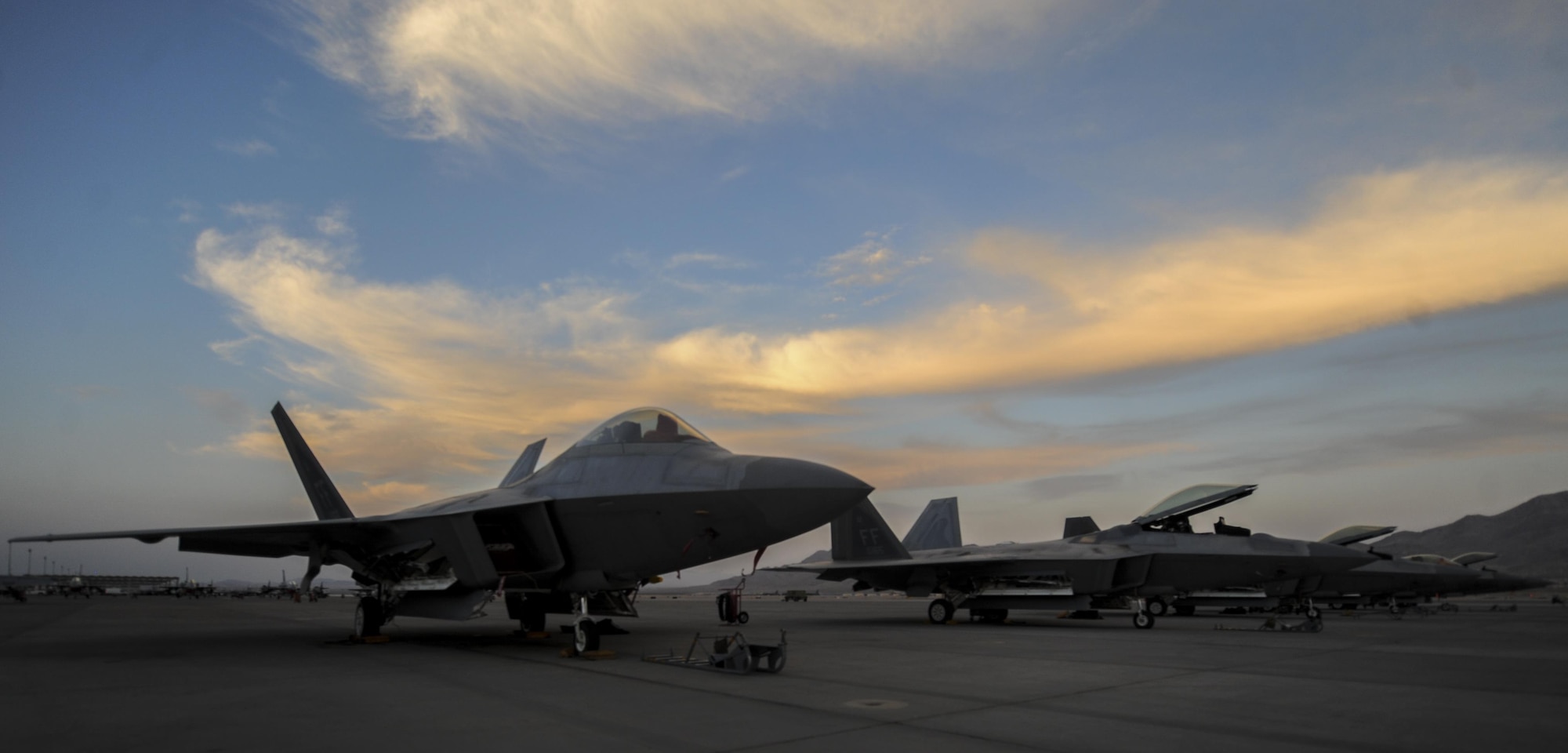 F-22A Raptors, assigned to the 27th Fighter Squadron, Joint Base Langley-Eustis, Va., sits on the runway before takeoff during Red Flag 16-3 at Nellis Air Force Base, July 25, 2016. In addition to daytime operations, Red Flag conducts training exercises during hours of darkness to train for low visibility environment. (U.S. Air Force photo by Airman 1st Class Kevin Tanenbaum/Released) 