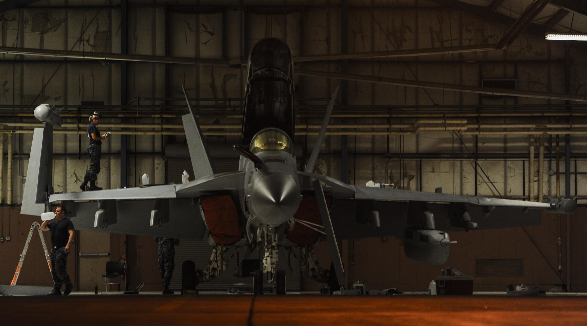 An EA-18G, assigned to the Electronic Attack Squadron 139, Whidbey Island Naval Air Station, WA., sits in a hangar as maintainers repair the aircraft during Red Flag 16-3 at Nellis Air Force Base, Nev. July 25, 2016. In addition to daytime operations, Red Flag conducts training exercises during hours of darkness to train for low visibility environment. (U.S. Air Force photo by Airman 1st Class Kevin Tanenbaum/Released)